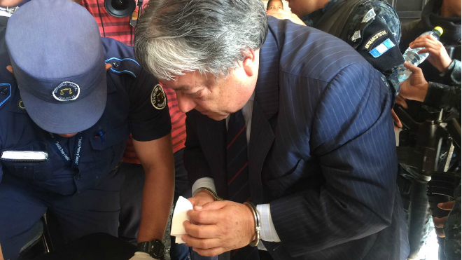 César Fajardo, diputado, capturado por el Caso Plazas Fantasma, a su ingreso a la Torre de Tribunales engrilletado frente a un agente del Organismo Judicial.