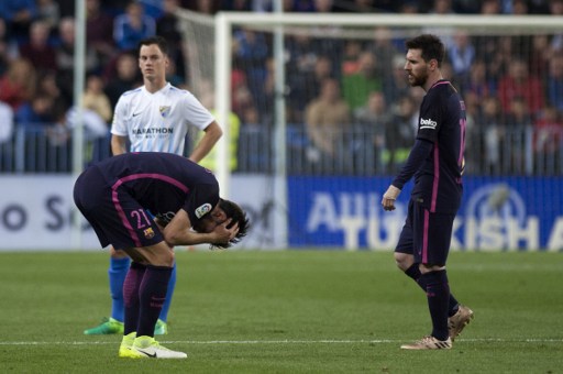 Los jugadores del Barcelona André Gomez y Lionel Messi lamentan la oportunidad desaprovechada tras perder ante el Málaga FC en el partido de este sábado de La Liga. AFP PHOTO / JORGE GUERRERO