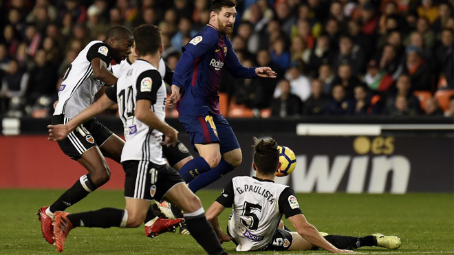 Barcelona's Argentinian forward Lionel Messi controls the ball in front of Valencia's Spanish defender Jose Luis Gaya Pena and Valencia's Brazilian defender Gabriel Paulista during the Spanish league football match Valencia CF and FC Barcelona at Mestalla stadium in Valencia on November 26,2017 JOSE JORDAN / AFP