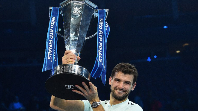 Bulgaria's Grigor Dimitrov holds the trophy as he celebrates winning his men's singles final match against Belgium's David Goffin on day eight of the ATP World Tour Finals tennis tournament at the O2 Arena in London on November 19, 2017. Dimitrov won the match 7-5, 6-4, 6-3. Glyn KIRK / AFP