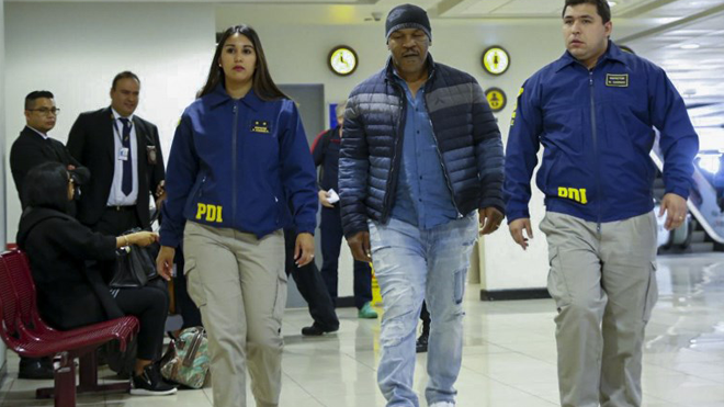 Handout picture realesed on November 9, 2017 by Chile's Investigation Police showing US former world heavyweight boxing champion Mike Tyson escorted by Chile's Investigations Police