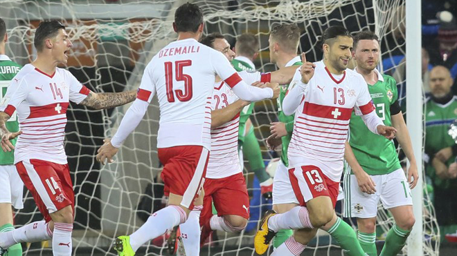 Switzerland's defender Ricardo Rodriguez (2R) celebrates scoring the opening goal from the penalty spot during the FIFA 2018 World Cup qualifier second round football match between Northern Ireland and Switzerland at Windsor Park in Belfast on November 9, 2017. Paul FAITH / AFP