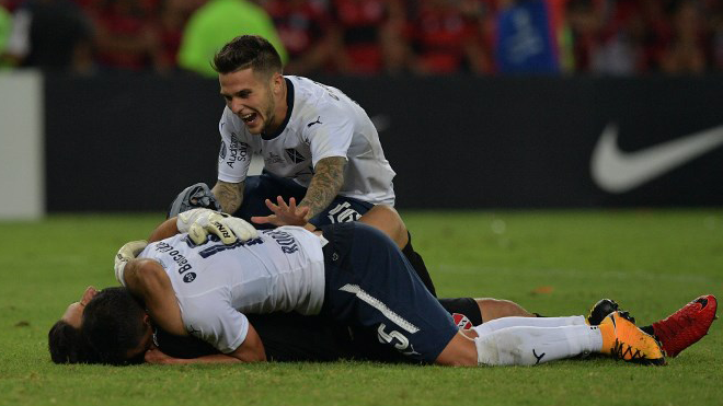Argentina's Independiente player Fabricio Bustos (top) celebrates with teammates after winning their 2017 Sudamericana Cup football final against Brazil's Flamengo at Maracana stadium in Rio de Janeiro, Brazil, on December 13, 2017. Carl DE SOUZA / AFP