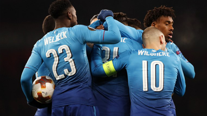 Arsenal's German-born Bosnian defender Sead Kolasinac (C) celebrates with teammates after scoring their first goal during the second leg of the Europa League Round of 32 football match between Arsenal and Ostersunds at the Emirates Stadium in London on February 22, 2018. Adrian DENNIS / AFP