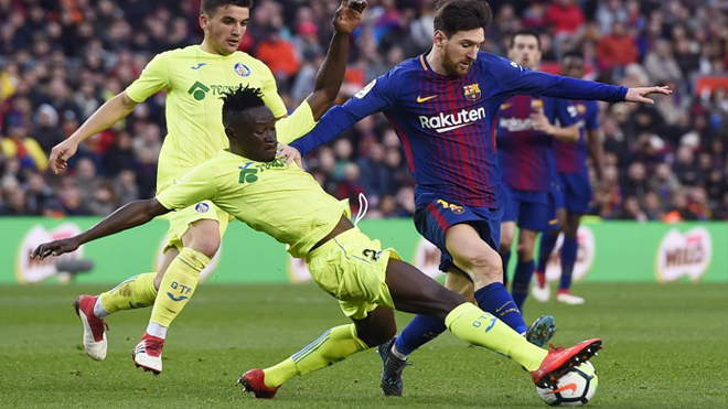 Getafe's Togolese defender Dakonam Djene (2L) vies with Barcelona's Argentinian forward Lionel Messi during the Spanish league football match between FC Barcelona and Getafe CF at the Camp Nou stadium in Barcelona on February 11, 2018. Josep LAGO / AFP