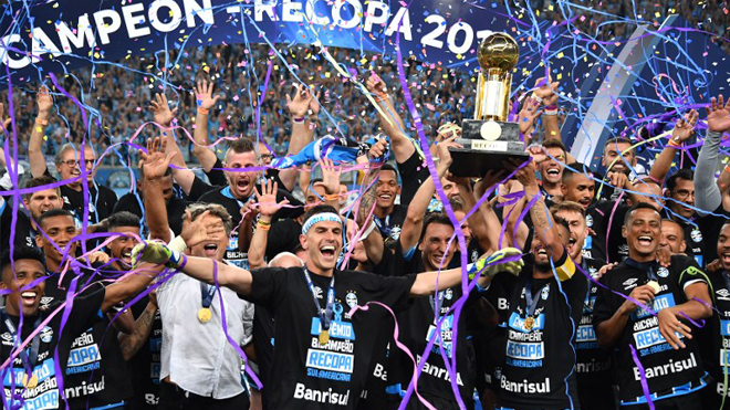 Brazilís Gremio players celebrate with the trophy after winning the Recopa Sudamericana 2018 final match against Argentina's Independiente at Arena Gremio, in Porto Alegre, Brazil, on February 21, 2018. NELSON ALMEIDA / AFP