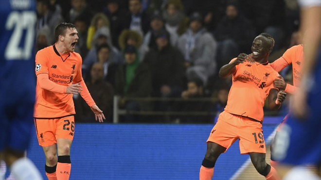 Liverpool's Senegalese midfielder Sadio Mane (R) celebrates with Liverpool's Scottish defender Andrew Robertson (L) after scoring the opening goal of the UEFA Champions League round of sixteen first leg football match between FC Porto and Liverpool at the Dragao stadium in Porto, Portugal on February 14, 2018. MIGUEL RIOPA / AFP
