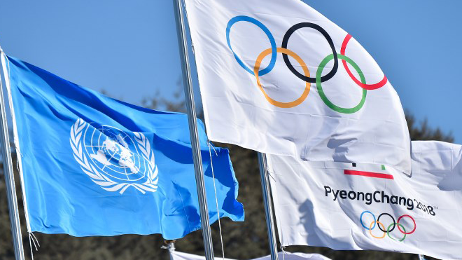 The Olympic flag flies next to the United Nations flag at the Olympic village, a few days prior to the PyeongChang 2018 Winter Olympic Games at the Olympic Village in Pyeongchang on February 6, 2018. LOIC VENANCE / AFP