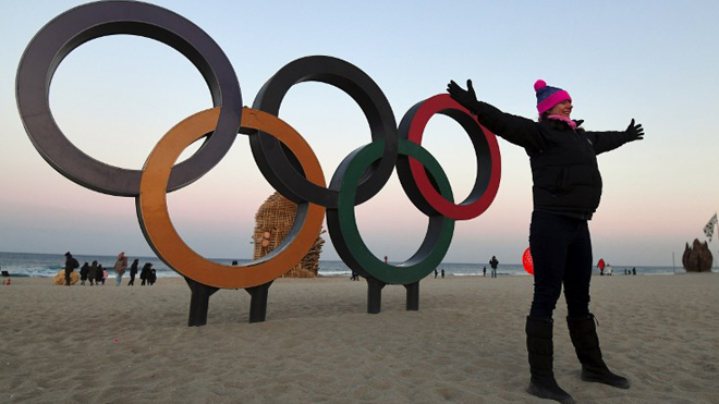 A woman poses for a photo in front of the Olympic rings at Gyeongpo beach in Gangneung on February 3, 2018, ahead of the Pyeongchang Winter Olympic Games. The 2018 Winter Olympic Games in South Korea will take place from February 9 to 25. JUNG Yeon-Je / AFP