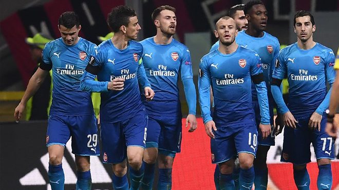 Arsenal's midfielder Aaron Ramsey of Wales (C) celebrates with teammates after scoring during the UEFA Europa League round of 16 first-leg football match AC Milan Vs Arsenal at the 'San Siro Stadium' in Milan on March 8, 2018. MARCO BERTORELLO / AFP