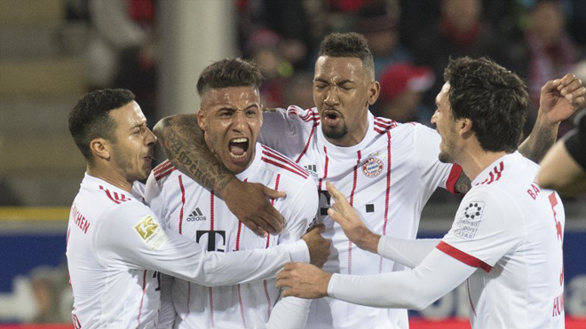 (L-R) Munich's Spanish midfielder Thiago, French midfielder Corentin Tolisso, defender Jerome Boateng and defender Mats Hummels celebrate after Tolisso scored during the German first division Bundesliga football match SC Freiburg versus Bayern Munich on March 4, 2018 in Freiburg. THOMAS KIENZLE / AFP
