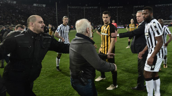 Paok president Ivan Savvidis (C) takes to the pitch carrying a handgun in his waistband (below C), after the referee refused a last minute goal on March 11, 2018 during the Greek Superleague football match PAOK Thessaloniki vs AEK Athens on March 11, 2018 in Thessaloniki. The match between PAOK Thessaloniki and AEK Athens for the Greek Super League at Toumpa stadium has been temporarily stopped after the referee and his assistants were deliberating whether to allow or disallow a 90th minute goal for PAOK. stringer / AFP
