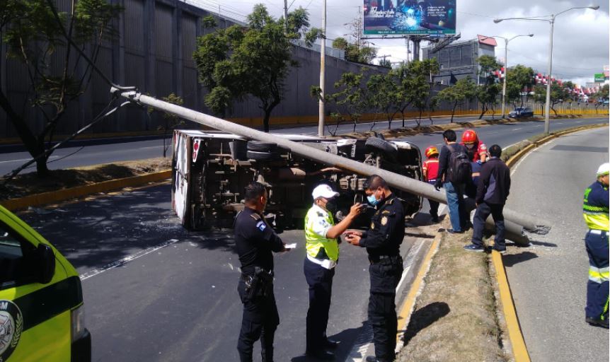 Cámara capta el momento en que un camión choca contra el arriate, vuelca y derriba un poste en plena vía