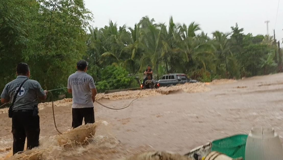 Captan el momento en que socorristas rescatan a un conductor que quedó atrapado en las correntadas de un río en Chicacao