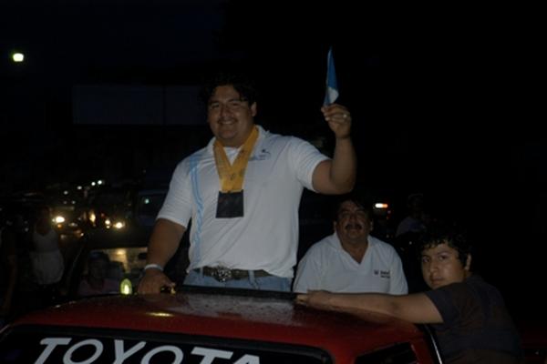 El campeón centroamericano de levantamiento de pesas Cristhian Alberto López  Bobadilla, alza una bandera. (Foto Prensa Libre: Edgar Girón)