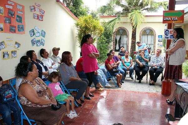 Cecilia Aguirre, auxiliar de  la PDH &mdash;derecha&mdash;, escucha a padres de familia que ratificaron la denuncia.