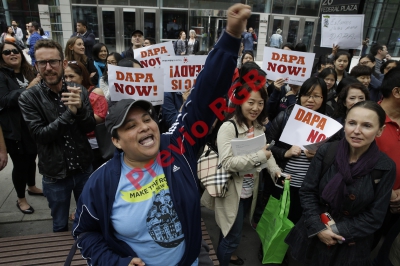 Irania Sanchez, (izquierda) originaria de Nicaragua, protesta a favor de las medidas ejecutivas que promulgó Obama en diciembre último. (Foto Prensa Libre: AP)