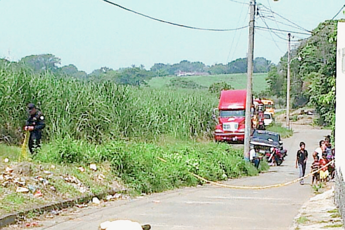 Vecinos de  la colonia Tarde Linda, en Santa Lucía Cotzumalguapa, observan cadáver de un hombre atacado a balazos. (Foto Prensa Libre: Enrique Paredes)