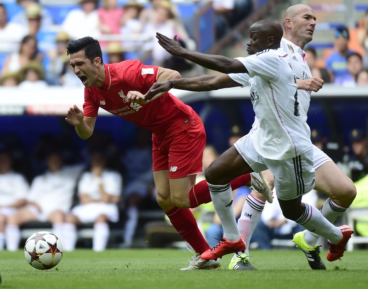 Luis Garcia del Liverpool pelea por el balón con Claude Makelele, mientras Zidane corre para el lado contrario durante "El Corazón Classic". (Foto Prensa Libre: AFP)