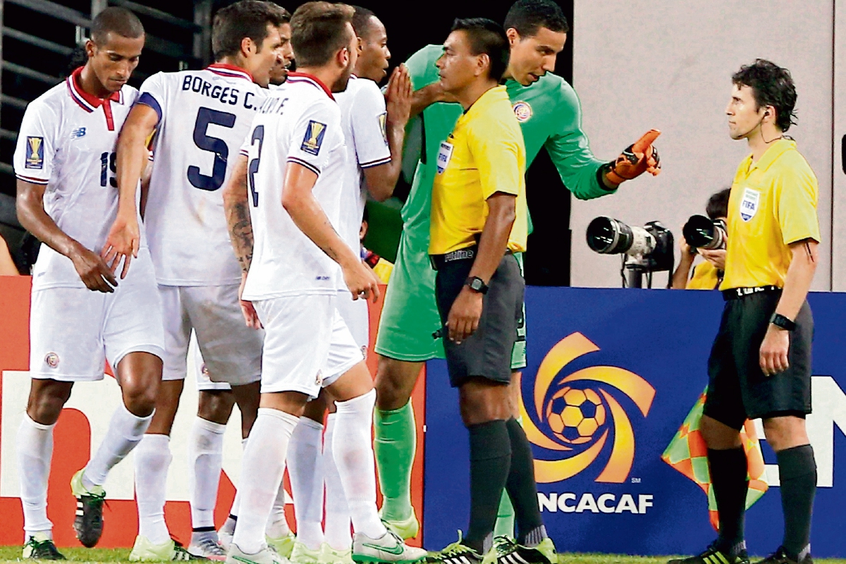 Wálter López recibe los reclamos de los futbolistas costarricenses, en el partido contra los mexicanos. (Foto Prensa Libre: AFP)