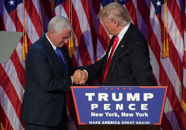 Donald Trump (d) saluda Mike Pence durante la noche de las elecciones. (Foto Prensa Libre: AFP)