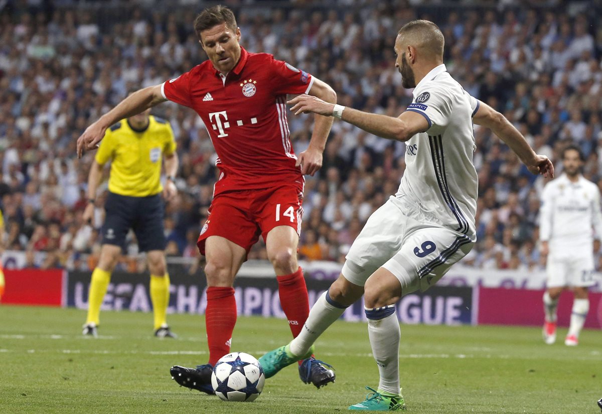 Xabi Alonso trata de frenar a Karim Benzema en el estadio Santiago Bernabéu. (Foto Prensa Libre: EFE)