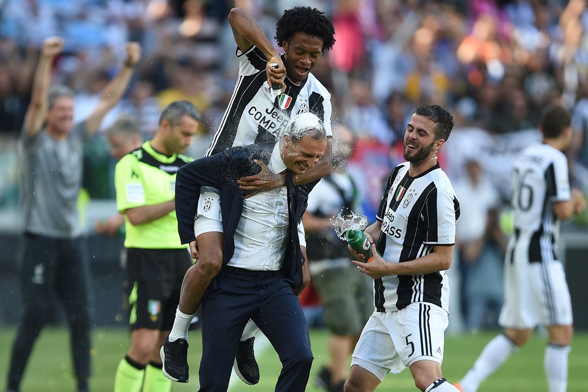 Juan Cuadrado festeja con el técnico Massimiliano Allegri, luego de que el equipo conquistó el Scudetto. (Foto Prensa Libre: AFP).