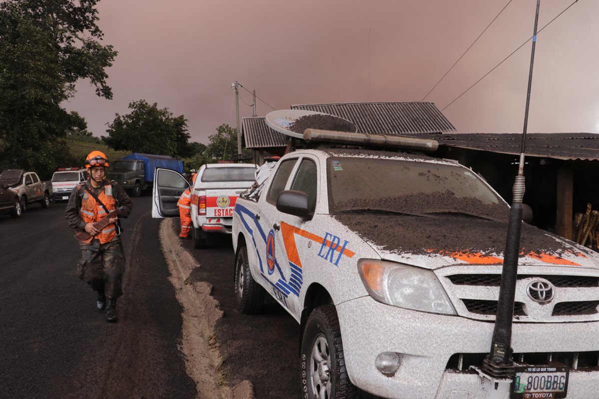 Un socorrista camina en La Soledad, aldea de Acatenango, en donde se ve oscuro por la gran cantidad de arena y hasta piedras que han caído. (Foto Prensa Libre: Conred)