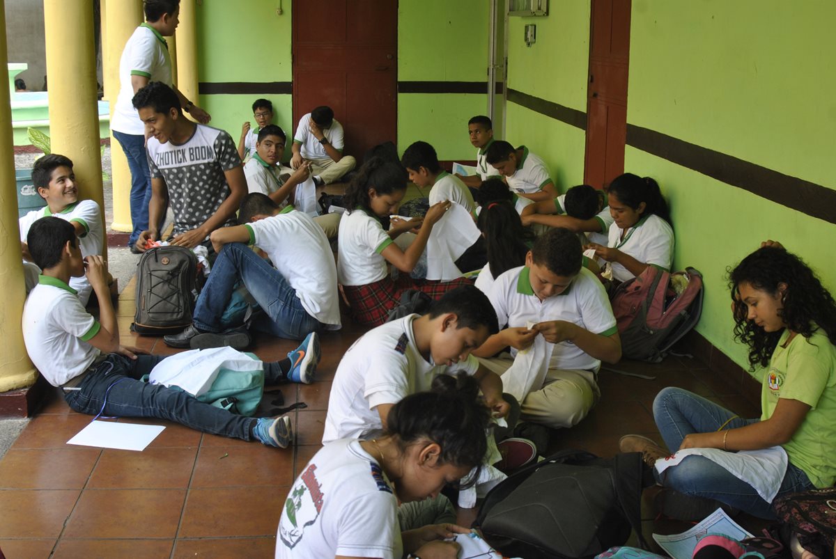 Jóvenes que cursan Básico en el Instituto Simón Bergaño y Villegas reciben clases en los corredores del Centro Cultural Arístides Crespo.(Foto Prensa Libre: Carlos Paredes)