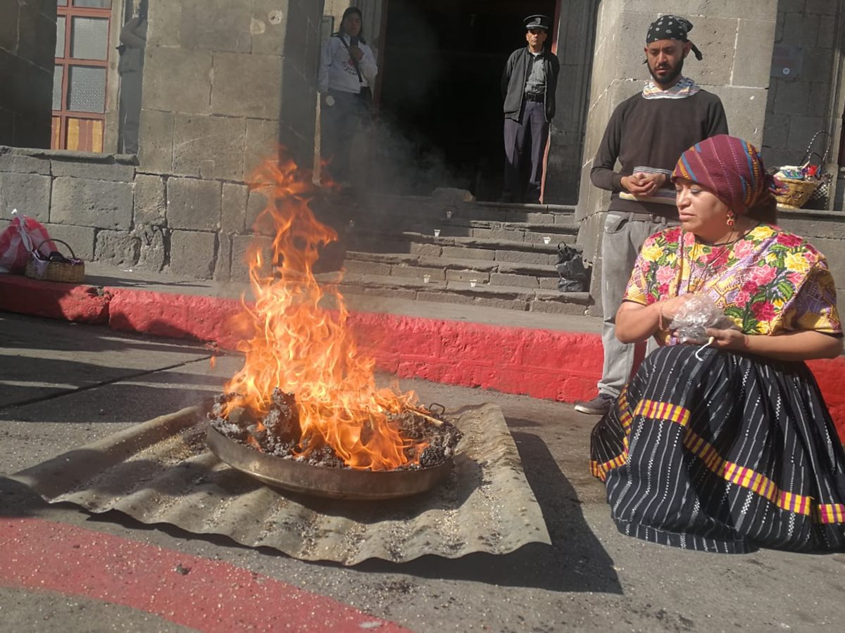 Una guía espiritual echa copal al fuego como parte de la ceremonia maya que se efectuó frente a la Casa de la Cultura. (Foto Prensa Libre: Fred Rivera)