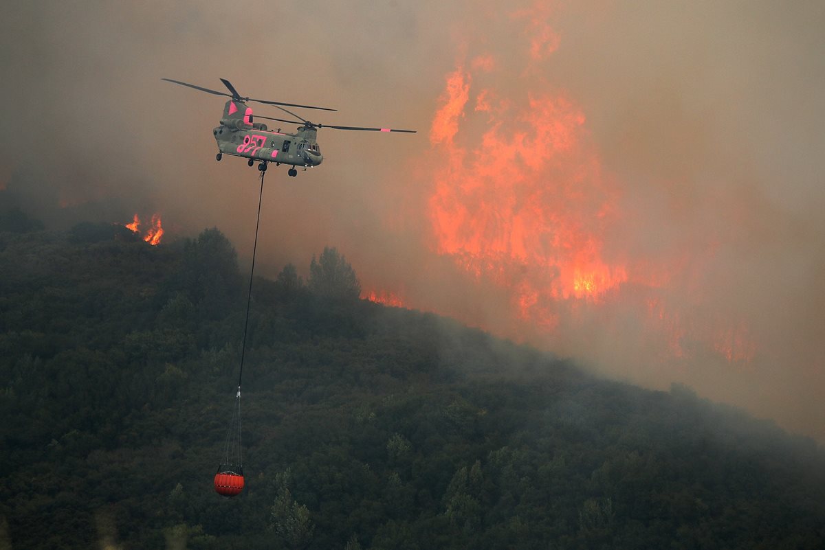 Un helicóptero participa en el control del incendio forestal en Lakeport, California. (AFP)