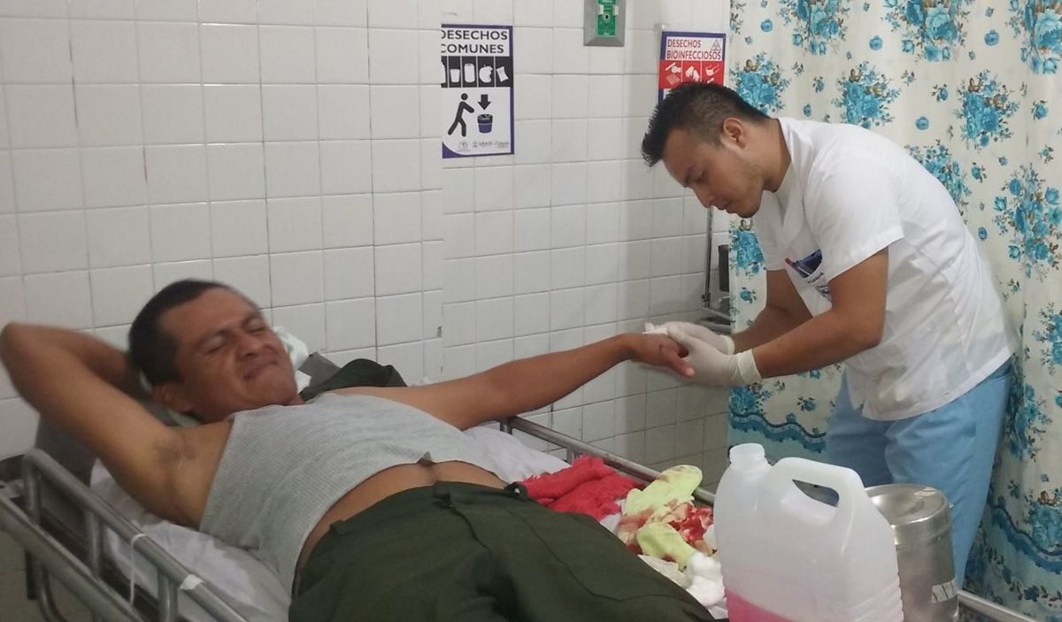 El agente de seguridad que frustró el asalto, es atendido por un para médico en la sala de urgencias del hospital de San Benito. Foto Prensa Libre: Rigoberto Escobar.