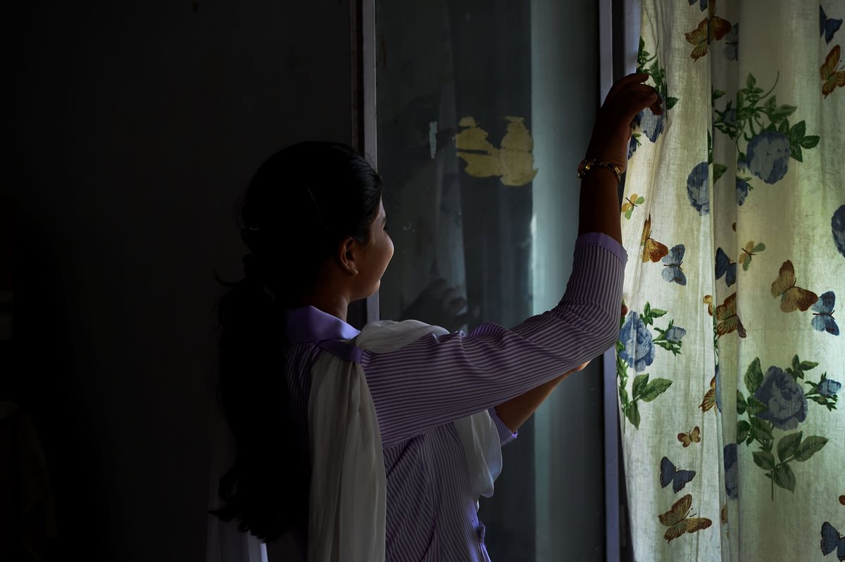 Esham Masih, hija de Asia Bibi, observa a través de la ventana en su vivienda en Lahore. (Foto Prensa Libre: AFP).