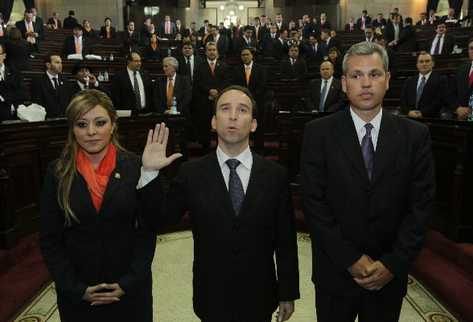 Jorge Eduardo de León Duque  —centro— presta juramento como nuevo procurador de los Derechos Humanos. Lo escoltan los diputados  Emilenne Aquino y  Christian Boussinot.