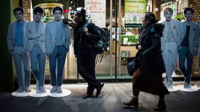 Limanol Adams, estudiante de la escuela de K-pop, posa junto a figuras de cartón de sus ídolos, la banda juvenil EXO. (MISHA FRIEDMAN/PRI)