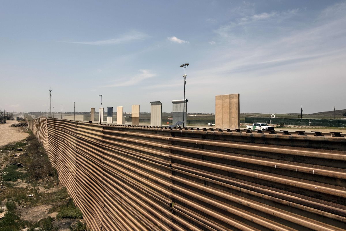 Un vehículo de la Patrulla Fronteriza estadounidense junto a los prototipos de muro fronterizo. (AFP).