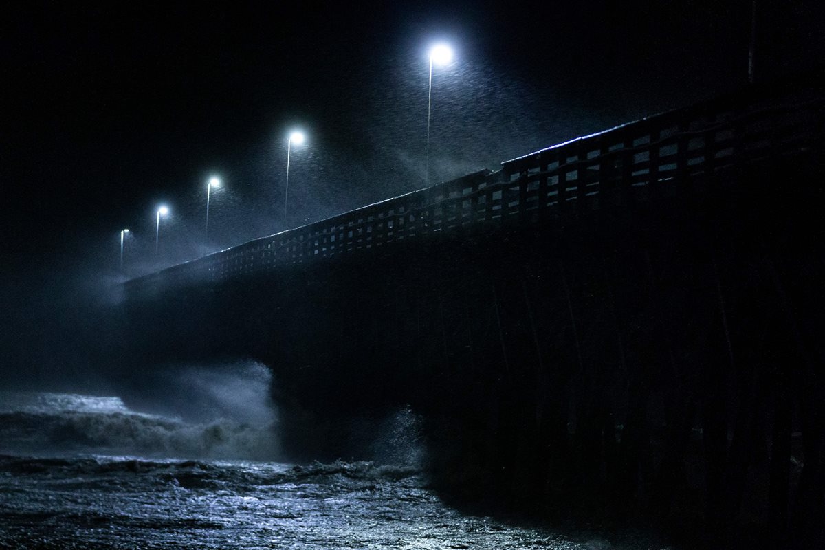 Las olas chocan contra un puente en Carolina del Sur. (Foto Prensa Libre: AFP)