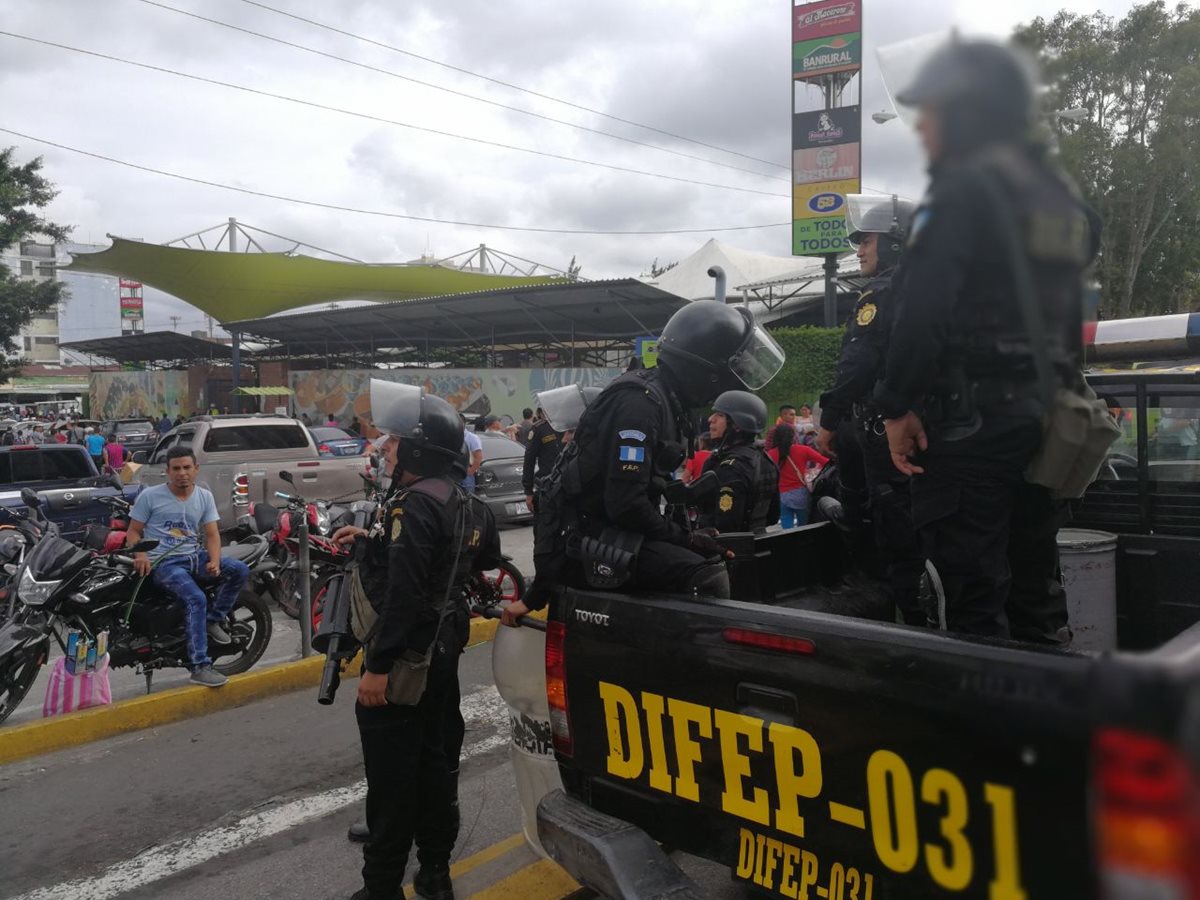 Agentes de la PNC trasladan a un juzgado a un presunto extorsionista capturado en la Plaza El Amate. (Foto Prensa Libre: Esbin García)