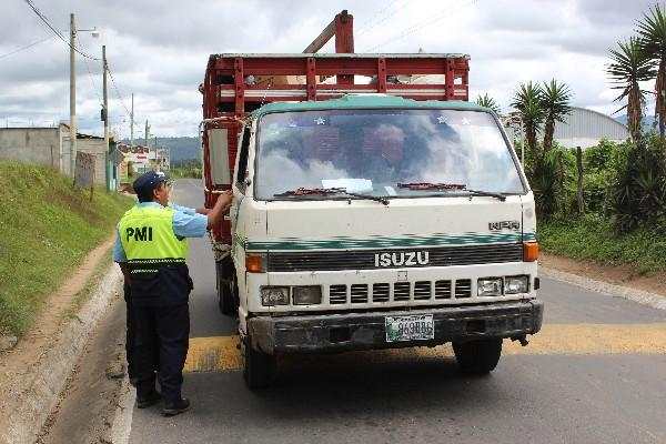 Policías municipales cobran a vehículos comerciales por ingreso en San Andrés Itzapa.