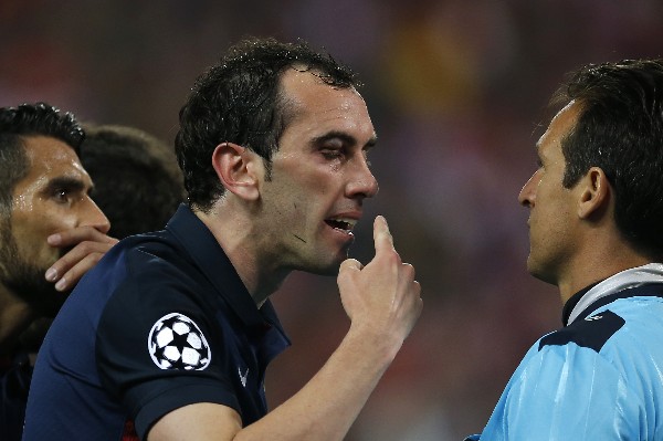 Diego Godín le reclama al árbitro, por el codazo recibido por Luis Suárez del Barcelona. (Foto Prensa Libre: AP)