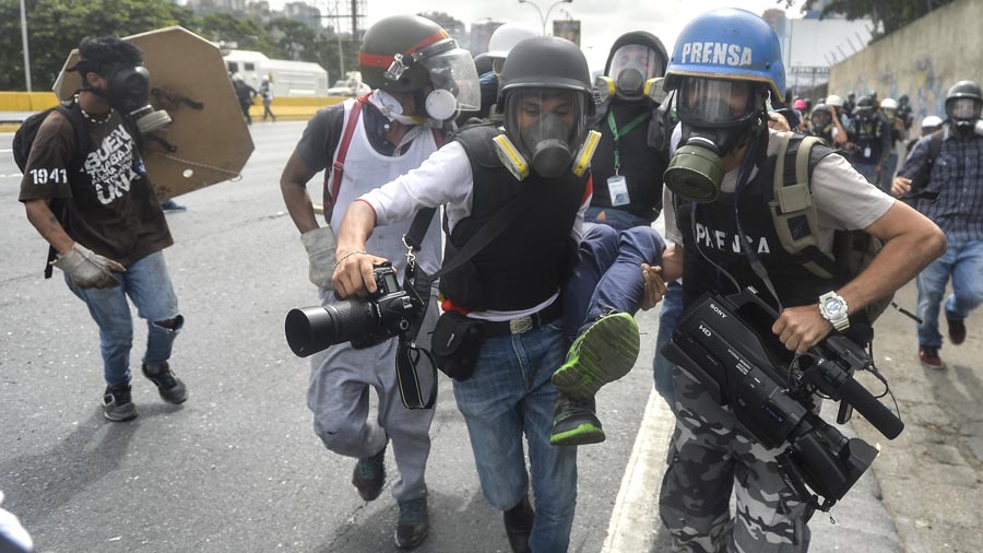 Un periodista es llevado herido por sus compañeros durante una protesta en Venezuela. (Foto: Hemeroteca PL)