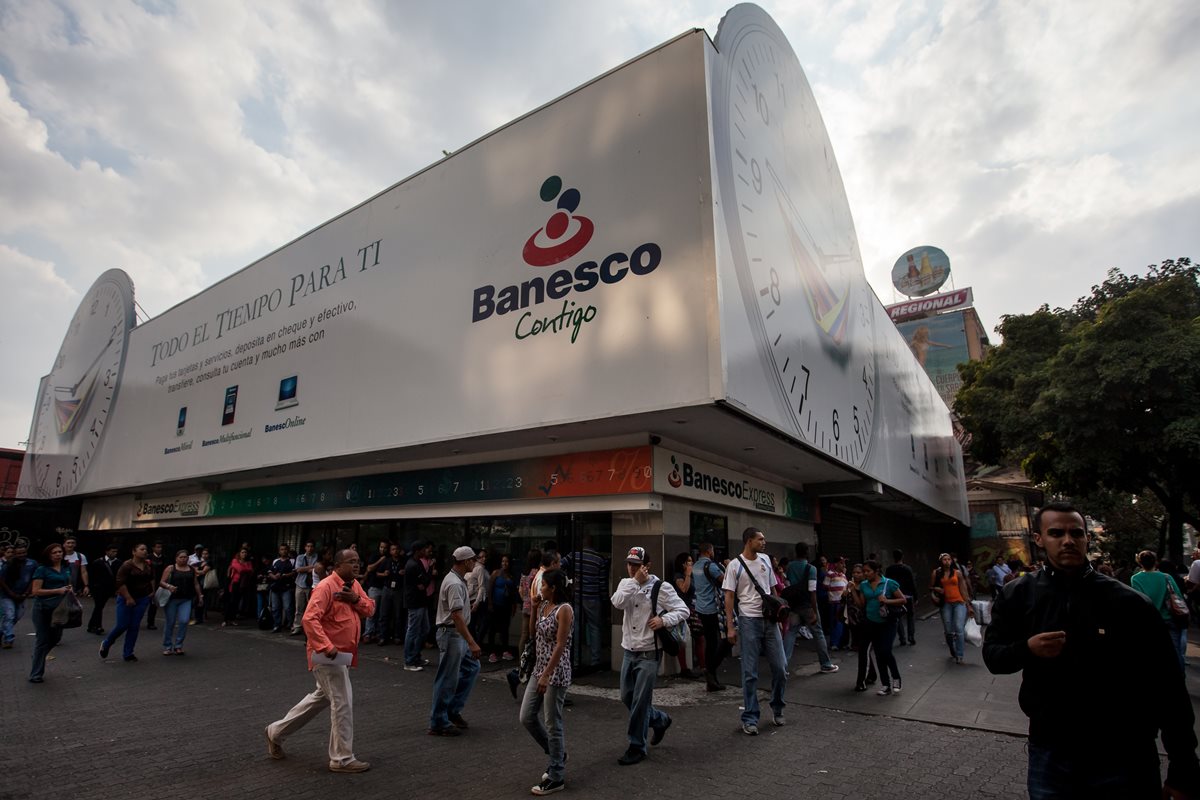 Decenas de personas hacen cola, en vano, en Venezuela, para retirar algo de dinero de cajeros de un conocido banco. (Foto PL: EFE)