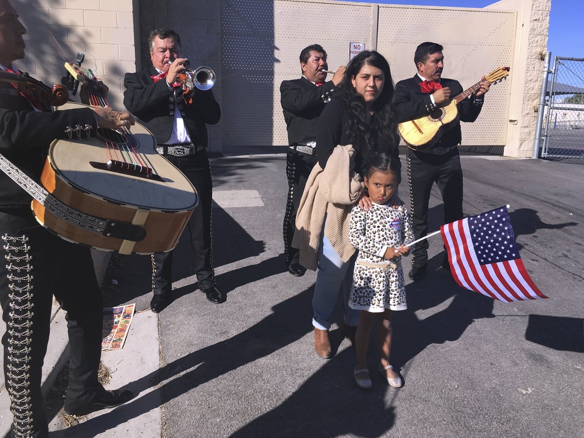 Una hispana con su niña caminan en una calle de Las Vegas mientras escuchan mariachis, la música tradicional mexicana. (Foto Prensa Libre: AP).