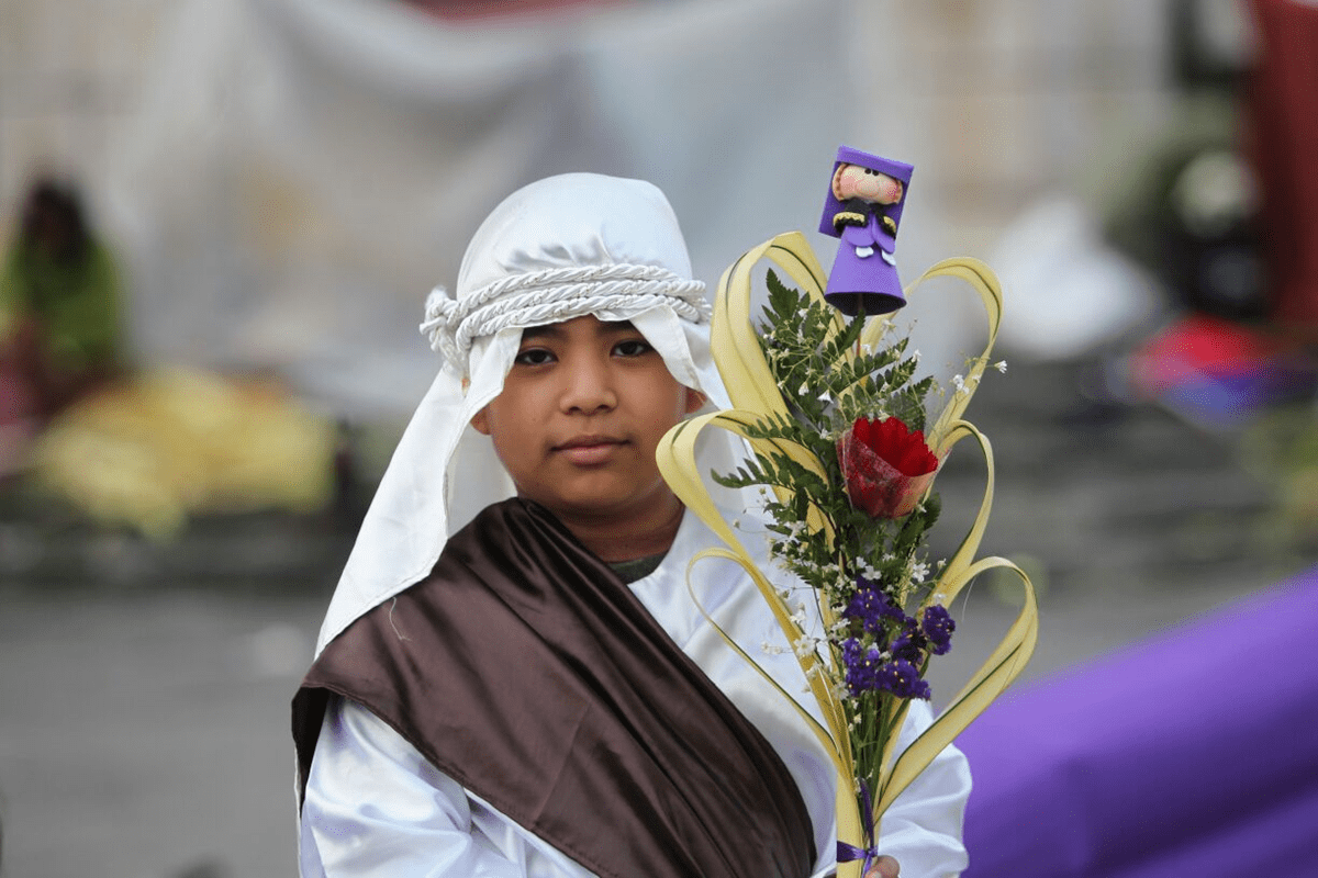 Un niño sostiene un ramo frente a la Catedral Metropolitana. (Foto Prensa Libre: Érick Ávila)