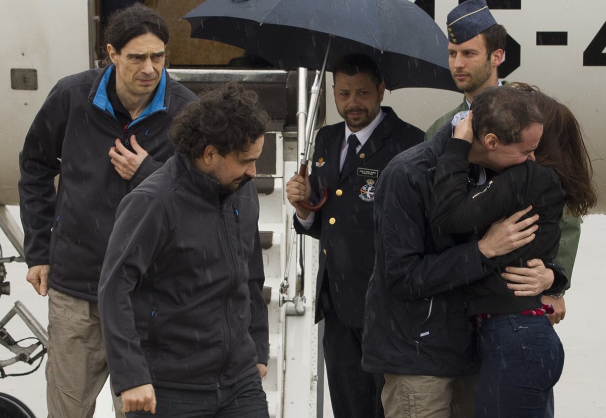 Los periodistas españoles, Antonio Pampliega, (abraza a una familiar), José Manuel López, (izquierda) y Ángel Sastre, en el momento que arriban a la base militar Torreón de Madrid, España. (Foto Prensa Libre: AP).