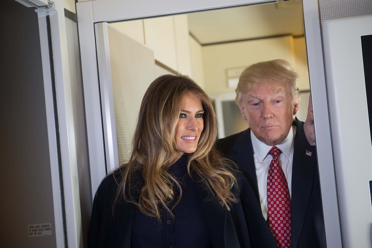 Melania Trump y su esposo el presidente de EE. UU., Donald Trump, hablan a los medios de prensa a bordo del avión presidencial. (Foto Prensa Libre: AFP)