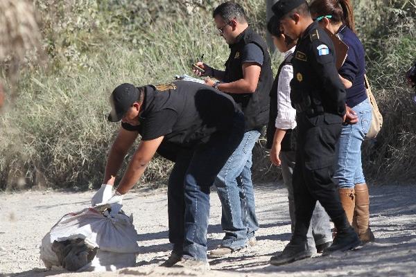 Fiscales del MP examinan la bolsa donde fue encontrado el cuerpo de una mujer.