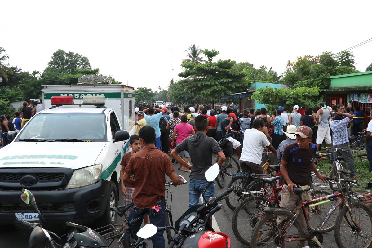 Curiosos permanecen en el lugar donde murió baleada la víctima. (Foto Prensa Libre: Enrique Paredes).