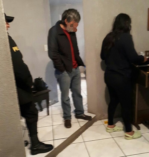 Uno de los detenidos sindicado de lavado de dinero, durante el momento de su captura. (Foto Prensa Libre: PNC)