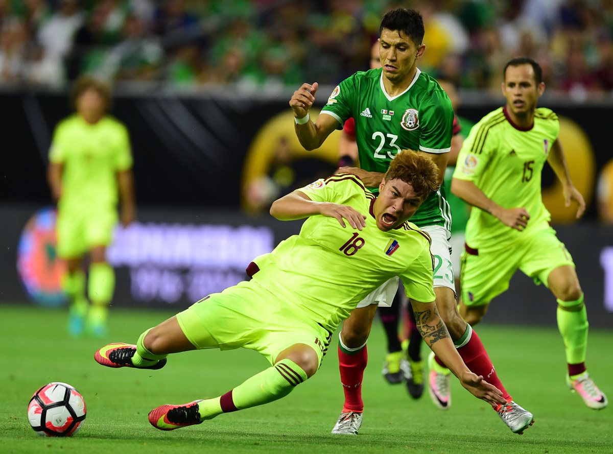 El venezolano Adalberto Penaranda izquierda supera al mexicano Jesus Molina, durante el partido que terminó empatado 1-1. (Foto Prensa Libre: AFP)